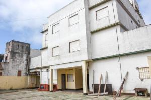 een oud wit gebouw met een watertoren bij Hotel Puntarenas in Mar de Ajó