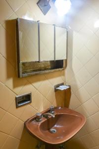 een badkamer met een wastafel en een spiegel bij Hotel Puntarenas in Mar de Ajó