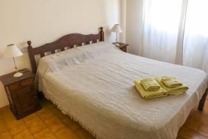 een slaapkamer met een bed met twee gele handdoeken erop bij Hotel Puntarenas in Mar de Ajó