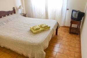 een slaapkamer met een bed met twee gele handdoeken erop bij Hotel Puntarenas in Mar de Ajó +1 foto