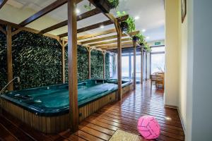 a hot tub in a room with a green wall at Pensjonat pod Samowarem in Tylicz +129 photos