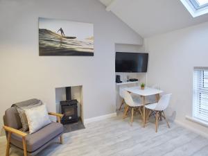 - un salon avec une cheminée, une table et des chaises dans l'établissement Host & Stay - The Surfer's Loft Apartment, à Saltburn-by-the-Sea