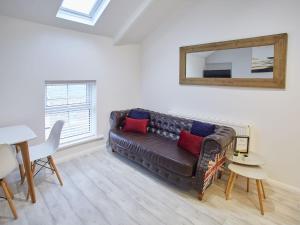 a living room with a brown couch and a mirror at Host & Stay - The Surfer's Loft Apartment in Saltburn-by-the-Sea
