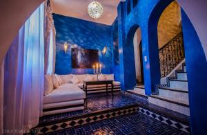 Lina Ryad & Spa في شفشاون: غرفة معيشة مع أريكة بيضاء وجدران زرقاء