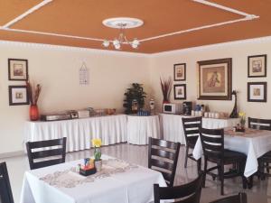 a dining room with tables and chairs with white tablecloths at Ecotel Southgate in Southgate