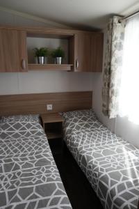 Camping Parcvalrose Mobile Home No 79 في لا لوند-ليه-مور: غرفة نوم صغيرة بها سرير ونافذة