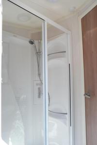 W łazience z przeszklonymi drzwiami znajduje się prysznic. w obiekcie Camping Parcvalrose Mobile Home No 79 w mieście La Londe-les-Maures