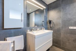 ein Badezimmer mit einem weißen Waschbecken und einem Spiegel in der Unterkunft De Berkenhof Aparthotel in Nes