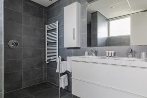 a bathroom with a sink, toilet and bathtub at De Berkenhof Aparthotel in Nes