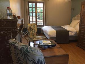 een kamer met 2 bedden en een tafel en stoelen bij Le moulin régnelot - Chambre d'hôtes in Verdelot