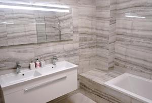 Baño blanco con lavabo y bañera en Apartmány Mia Valtice, en Valtice