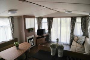 uma sala de estar com um sofá e uma mesa em Camping Parcvalrose Mobile Home No 79 em La Londe-les-Maures