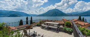 a patio with a table and chairs next to a lake at Casa San Giorgio Varenna in Varenna