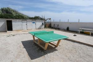 a green ping pong table sitting on top of a beach at GRAND SUD in Hyères