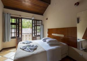 ein Schlafzimmer mit einem Bett mit Handtüchern darauf in der Unterkunft Lonier Ilha Inn Flats in Abraão