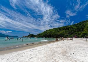 a beach with a bunch of people in the water at Lonier Ilha Inn Flats in Abraão