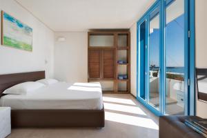 a bedroom with a bed and a view of the ocean at Solmaris Seaside - Luxury B&B sul mare a Campomarino in Maruggio