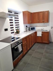 a kitchen with wooden cabinets and a stove top oven at Chalupa Horní Bečva in Horní Bečva