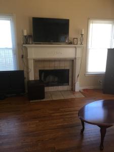 a living room with a fireplace with a tv above it at A Room for You! in Atlanta