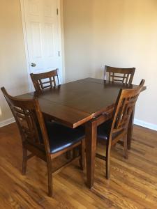 a wooden dining room table with four chairs at A Room for You! in Atlanta