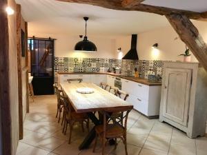 a kitchen with a wooden table and chairs at Venosc, La Grange Auguste, accès piscine et espace bien-être in Vénosc