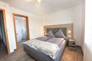 1 Schlafzimmer mit einem großen Bett und einem Badezimmer in der Unterkunft 1a Gästehaus am Hafen in Nürnberg