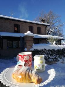 - un croissant sur une assiette à côté d'une tasse et une tasse de café dans l'établissement Il Castagneto, à Camerino