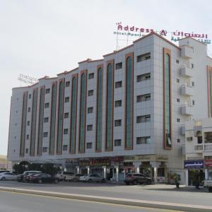 Address hotel Apartments العنوان للشقق الفندقية في Aş Şa‘arah: مبنى كبير به سيارات تقف في موقف للسيارات