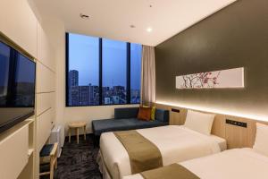 um quarto de hotel com duas camas e uma janela em hotel MONday Premium TOYOSU em Tóquio