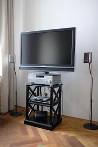 uma televisão de ecrã plano numa bancada com duas colunas em Pawlansky Apartments No.4 em Praga