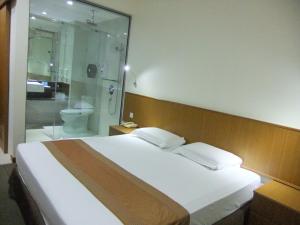 a bedroom with a large bed and a shower at New Cape Inn in Singapore
