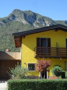 een geel huis met een berg op de achtergrond bij Casa Alice in Crone