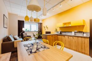 kuchnia i salon z drewnianym stołem i krzesłami w obiekcie Mosquito Silesia Apartments w mieście Katowice