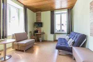 a living room with a blue couch and a chair at Altes Schulhaus in Zeltingen-Rachtig