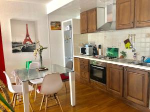 una cocina con mesa y una cocina con la torre Eiffel en Appartement vue mer, en Bastia
