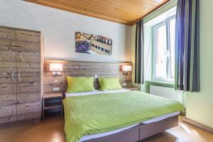 a bedroom with a bed with green sheets and a window at Altes Schulhaus in Zeltingen-Rachtig +19 photos