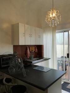 a kitchen with a black counter top and a chandelier at Grace in Pretoria