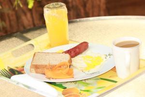 um prato de comida de pequeno-almoço e uma chávena de sumo de laranja em Pandeinge em Windhoek