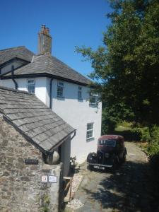 an old car parked in front of a white house at Boots Cottage in Bude