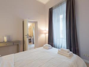 - une chambre avec un lit blanc et des serviettes dans l'établissement Ara Pacis Luxury Apartments by CapriRooms, à Rome