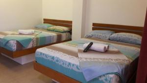 - 2 lits dans une chambre avec un téléphone dans l'établissement Eriko's House, à Boracay