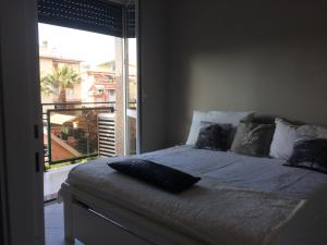 een slaapkamer met een bed en een groot raam bij Casa Ginestra Mare in Bordighera