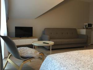 ヤスタルニャにあるWilla Przystańのベッド、ソファ、テレビが備わる客室です。