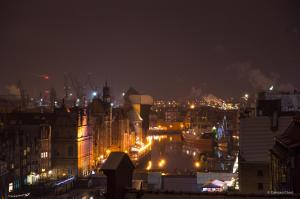 a view of a city at night with lights at WaterLane Island Hostel&Apartments in Gdańsk