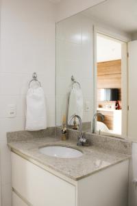 a bathroom counter with a sink and a mirror at Brasilia Boutique Flats in Brasília