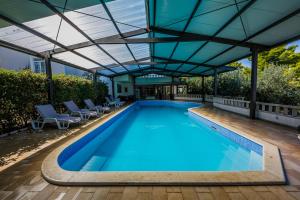 an indoor swimming pool with a pergola over it at Hotel Sveti Kriz in Trogir