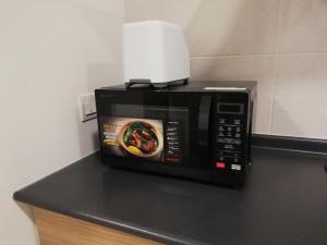 a microwave with a picture of a bowl of food at EVO Soho Suites, Bangi in Kampong Sungai Ramal Dalam