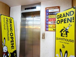 an elevator in a building with signs on the wall at 24 Guesthouse Seoul City Hall in Seoul