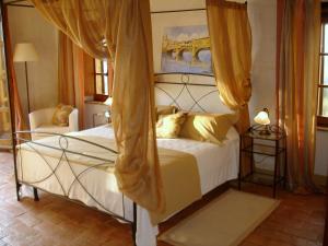 a bedroom with a large white bed with yellow pillows at Tenuta Fattoria Vecchia in Scansano