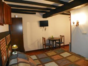 a living room with a table and a tv at Posada Gema in Ubiarco
